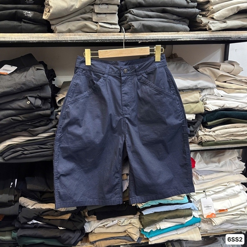 Quần short ống rộng kiểu carpenter màu xanh navy, mặt trước, treo móc gỗ trước kệ quần áo xếp chồng